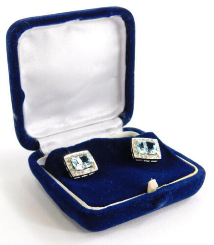 TOP BID £200 - A pair of aquamarine and diamond earrings, the central rectangular cut stone in claw setting, surrounded by tiny diamonds, in a white metal setting, unmarked, with butterfly backs, stamped 750, 5.2g all in.