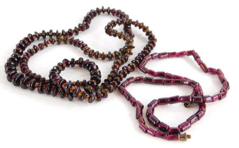 Two thin beaded necklaces, to include an Indian garnet and red and gold thread necklace of graduated design, 37cm drop, together with another purple beaded example, with silver clasp, 42cm long overall. (2)