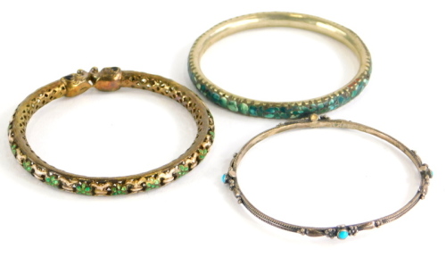 Three bangles, to include a silver bangle set with turquoise stones, 6.5cm diameter, a silver gilt an enamel elephant bangle, 6.5cm diameter and a further example set with fragments of turquoise, stamped made in India. (3)