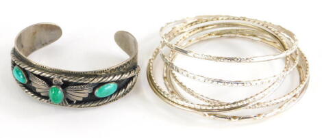 A group of bangles and bracelets, to include an eagle bangle, set with three turquoise stones, white metal, unmarked, and seven various silver coloured bangles.