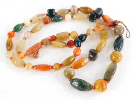 A hardstone necklace, set with various coloured agate and jade beads, of varying sizes and shaped, on a gold and red thread string, 116cm long overall.