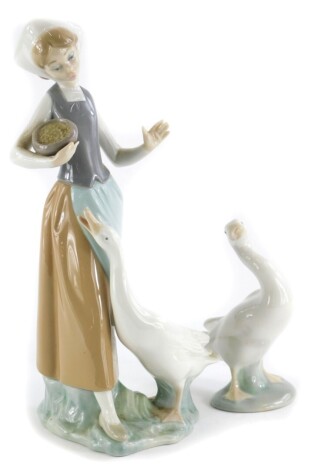 A Lladro porcelain figure, of a young girl with a goose, (AF), and a Lladro goose. (2)