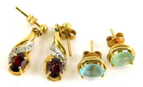 Two pairs of 9ct gold stone set earrings, to include a pair of aquamarine studs, and a pair of 9ct gold drop earrings set with garnet and CZ stones, each with butterfly backs, 3.2g all in.