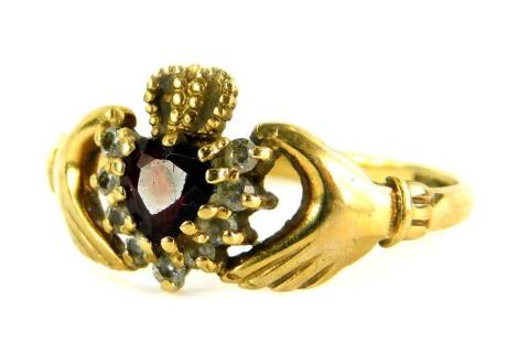 A 9ct gold Claddagh dress ring, with heart shaped central garnet stones, surrounded by white stones with a gold crown, ring size R, 2.2g all in.