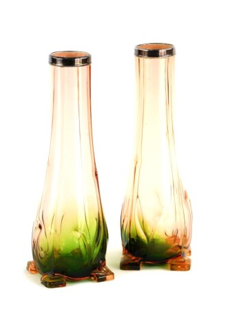 A pair of early 20thC Art Nouveau style pink and green glass vases, each with a silver collar, on square feet, 20cm high.