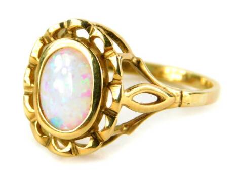 A 9ct gold opal dress ring, the oval opal in a rub over setting, with pierced design, gold metal flower type border, on splayed shoulders, ring size L, Sheffield import marks, 2g all in.