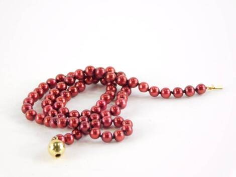 A cultured pearl single strand necklace, with red glossy finish, on a yellow metal ball clasp, stamped 375, 45cm long overall.