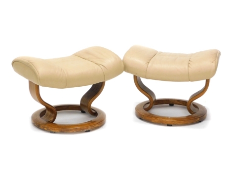 A pair of cream leather Stressless footstools. (AF)