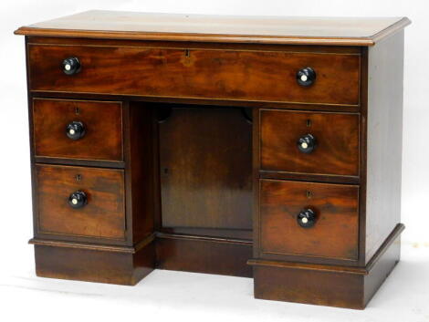 A Victorian kneehole desk, with a rectangular top with a moulded cornice, above a frieze drawer and tow smaller drawers, flanking a central cupboard door, each with ebonised turned wooden handles, on a plinth, 79cm high, 112cm wide. 52cm deep.