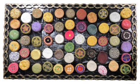 An impressive collection of Kufi hats of various embroidered coloured design, (57), together with a hand made papier mache display panel, 132cm x 229cm.