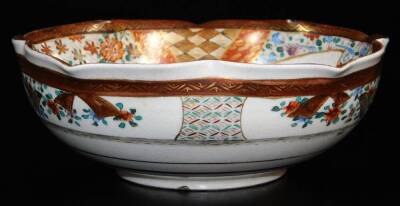 A Japanese lobed Satsuma bowl, decorated with overlapping shaped panels depicting women and children in a garden, books and gifts on a table, chrysanthemums, diaper designs, floral patterns, etc., the exterior with bands of fans, flowers, etc., illegible - 2