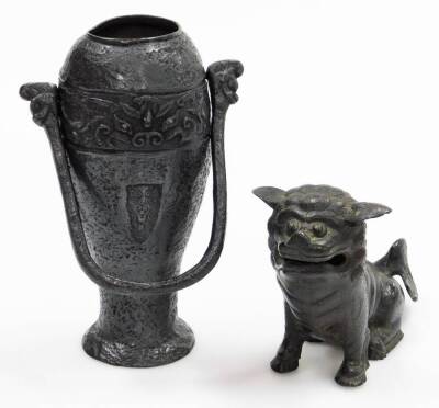 A bronze temple dog, with mouth open, raised on front paws, 14cm high, a vase of tapering circular form, with emblem to the centre and upper banding with swing handle, on a circular foot. (2)