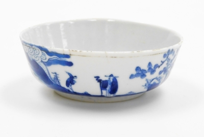 A Chinese blue and white shallow dish, decorated with figures, trees and calligraphy, the exterior with further decoration of the same design, four character hallmark beneath, possibly 18thC, 12cm diameter.