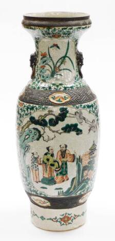 A Chinese crackle glazed baluster vase, decorated in orange and green enamels with sages in grove, floral sprays between dark unglazed bands, four character Kangxi mark beneath, 62cm high.