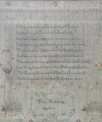 An early 19thC wool work sampler stitched with the alphabet and a star