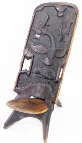 Tribal Art. A carved African hardwood seat, the tall back with carvings of fish, on spoon inset seat, 106cm high x 46cm wide.