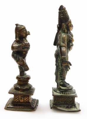 An Indian Hindu bronze figure of Krishna, modelled standing on one leg holding a ball of butter, 8.5cm high, bronze figure of Parvati, modelled standing holding a lotus flower, raised on a square base, 10cm high, and a further figure of a deity, possibly - 8