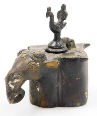 An Indian bronze elephant's head inkwell, of quatrelobe form, the hinged lid surmounted with a bird, 10cm wide.