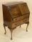 A walnut bureau with two drawers on cabriole legs