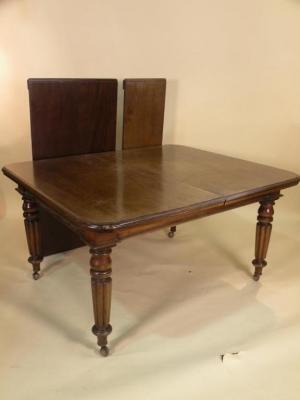 A Victorian mahogany extending dining table with two loose leaves