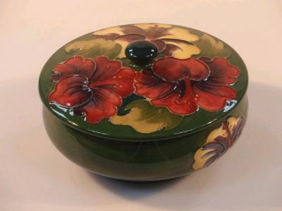 A Moorcroft circular squat bowl and cover decorated with lilies on a green ground