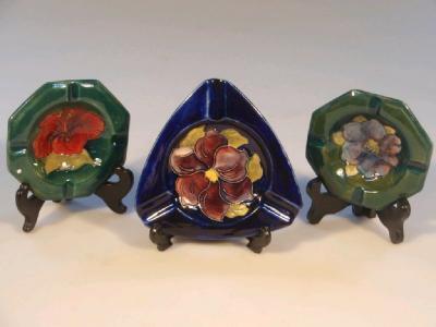 Two Moorcroft octagonal ashtrays created with flower heads on a green ground