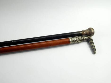 A silver topped ebony walking stick, 85cm long, and a malacca cane with a plated handle cast with a serpent and chased with foliate scrolls, 83cm long, owned by J Kerridge, a member of The Doyly Carte Opera, London, (2).