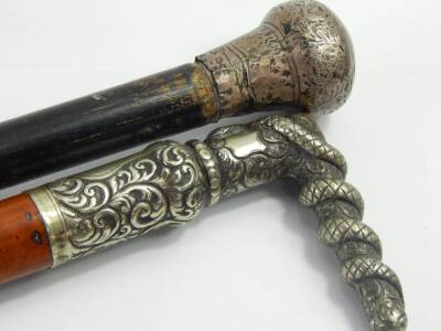 A silver topped ebony walking stick, 85cm long, and a malacca cane with a plated handle cast with a serpent and chased with foliate scrolls, 83cm long, owned by J Kerridge, a member of The Doyly Carte Opera, London, (2). - 2