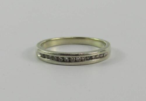 A white metal and diamond half hoop eternity ring, stamped 9ct, size K, 2.0g.