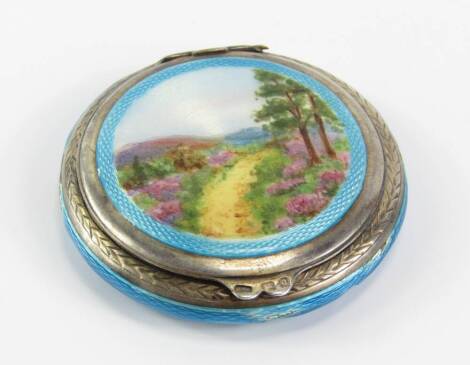 A George V silver and turquoise guilloche enamel compact, the lid painted with a moorland landscape, London 1929, 1.81t oz total weight, (AF).