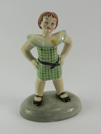 A Beswick pottery figure, of a girl, mid 20thC, modelled standing in a chequered dress with her hands on her hips, raised on an oval base, No 442, impressed and printed marks, 20cm high.