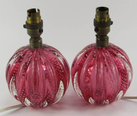 A pair of Murano cranberry glass table lamps, of globuler fluted form with air bubble inclusions, 20cm high