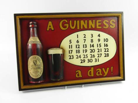 A Guinness relief carved and wooden advertising calendar wall plaque, A Guinness ... a day!, 32cm x 48cm.