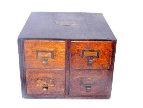 An oak card index cabinet, of four drawers, bearing labels for The National Deposit Friendly Society, Lincoln, 39.5cm x 40cm x 29cm.