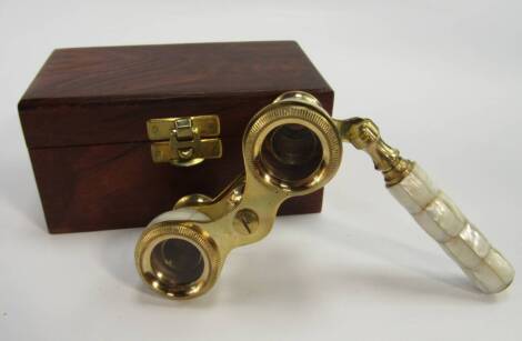 A pair of mother of pearl bound gilt brass opera glasses, wooden boxed.