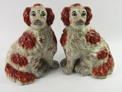 A pair of reproduction Staffordshire modelled spaniel figures, with liver markings and gilt chains.