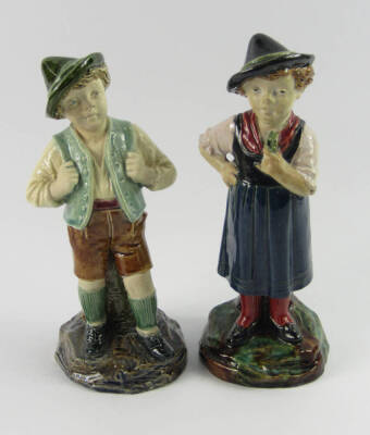 A pair of Bernard Bloch figural majolica spill vases, late 19thC, modelled as a boy and girl in Alpine costume, raised on naturalistic bases, impressed marks, 22cm high.