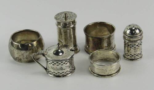 Silver condiments and napkin rings, comprising a George V pepperette, Sheffield 1910, mustard pot and pepperette, Birmingham 1926, and three napkin rings, 3.65t oz.