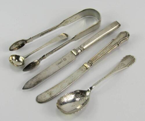 Silver flatware, including a pair of George IV sugar tongs, London 1826, George III salt spoon, crest engraved, jam spoon, Sheffield 1922, 1.54t oz, and two silver handled knives.