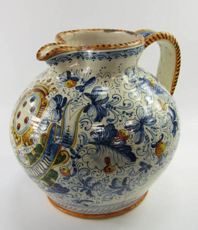 An Italian maiolica water jug, of bulbous form decorated with a coat of arms and motto against a ground of fruit and leaves, 38cm high.