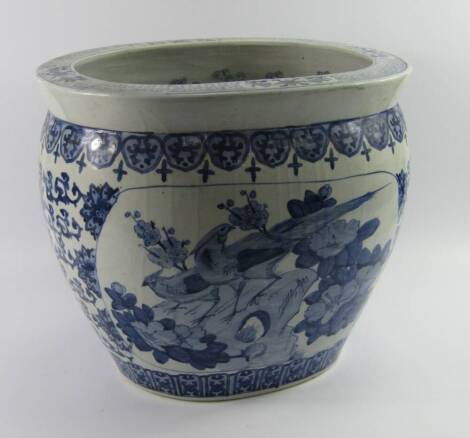 A Chinese blue and white porcelain jardiniere, of oval form decorated with reserves of peacocks and pheasants against a floral ground, 42cm x 33cm x 36.5cm.