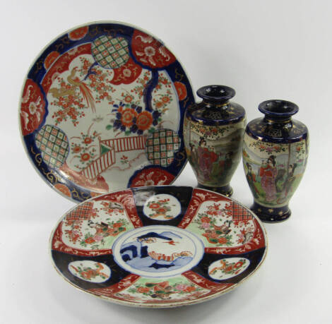 A group of Oriental ceramics, comprising a Japanese Imari dish decorated with a bird in a garden, 30.5cm diameter, Chinese Imari dish decorated with panels of flowers and a lady in a garden, 30.5cm diameter, and a pair of Satsuma vases of baluster form re