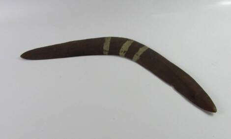 Tribal Art. An Australian Aboriginal boomerang, with three white stripes, 56cm wide.