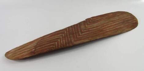 Tribal Art. An Australian Aboriginal broad shield, decorated with a zig-zag type pattern, picked out in red, possibly Western Australia, incomplete, 61cm long.