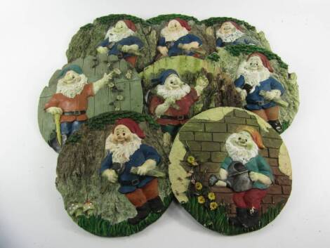 A set of eight relief moulded gnome garden plaques, each 22cm diameter.