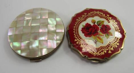 Two Stratton compacts, one with mother of pearl parquet decoration, the other enamel decorated with roses against a red ground.