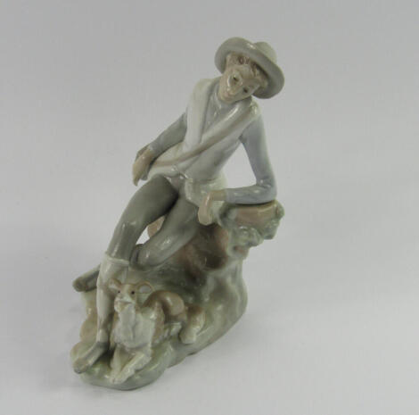 A Lladro porcelain figure of a travelling youth, modelled seated on a tree bough with a dog at his side, impressed marks, 20cm high.