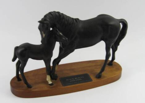 A Beswick Connoisseur model of Black Beauty and foal, matt black, on an oval wooden base.