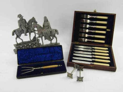 A cased set of silver plated dessert knives and forks, together with a Trident pickle fork, a pair of knife stands and a pair of cast aluminium figures of Edward VII and Alexandra on horseback.