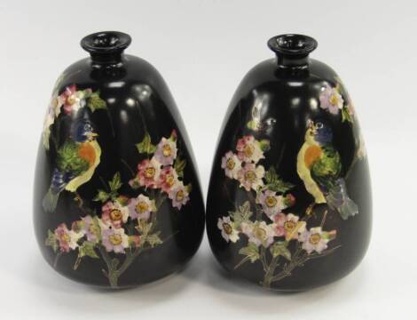 A pair of Bretby pottery vases, of tapering form decorated with birds, insects and apple blossom against a black ground, impressed marks, 21cm high.